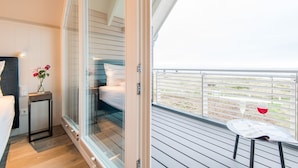 Une chambre moderne avec une porte vitrée donnant sur un balcon.