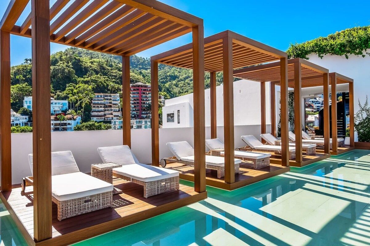 Ein Poolbereich auf dem Dach mit Liegestühlen und einer Pergola.