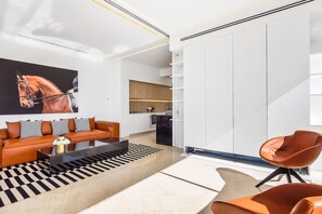 A modern living room with a sofa, coffee table, and a large painting of a horse.