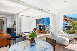 A modern living space with a glass wall, a round marble table, and a white sofa.