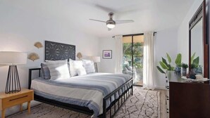 Un dormitorio moderno con cama, mesita de noche y ventilador de techo.