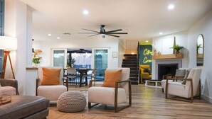 Una sala de estar moderna con chimenea, dos sofás, una mesita de centro y un comedor al fondo.