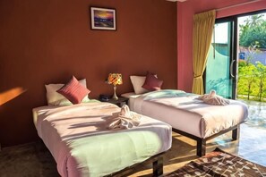 A room with two beds, a nightstand, a lamp, and a view of greenery through a sliding door. - Sea Stone Hotel Sichon (Sichon)
