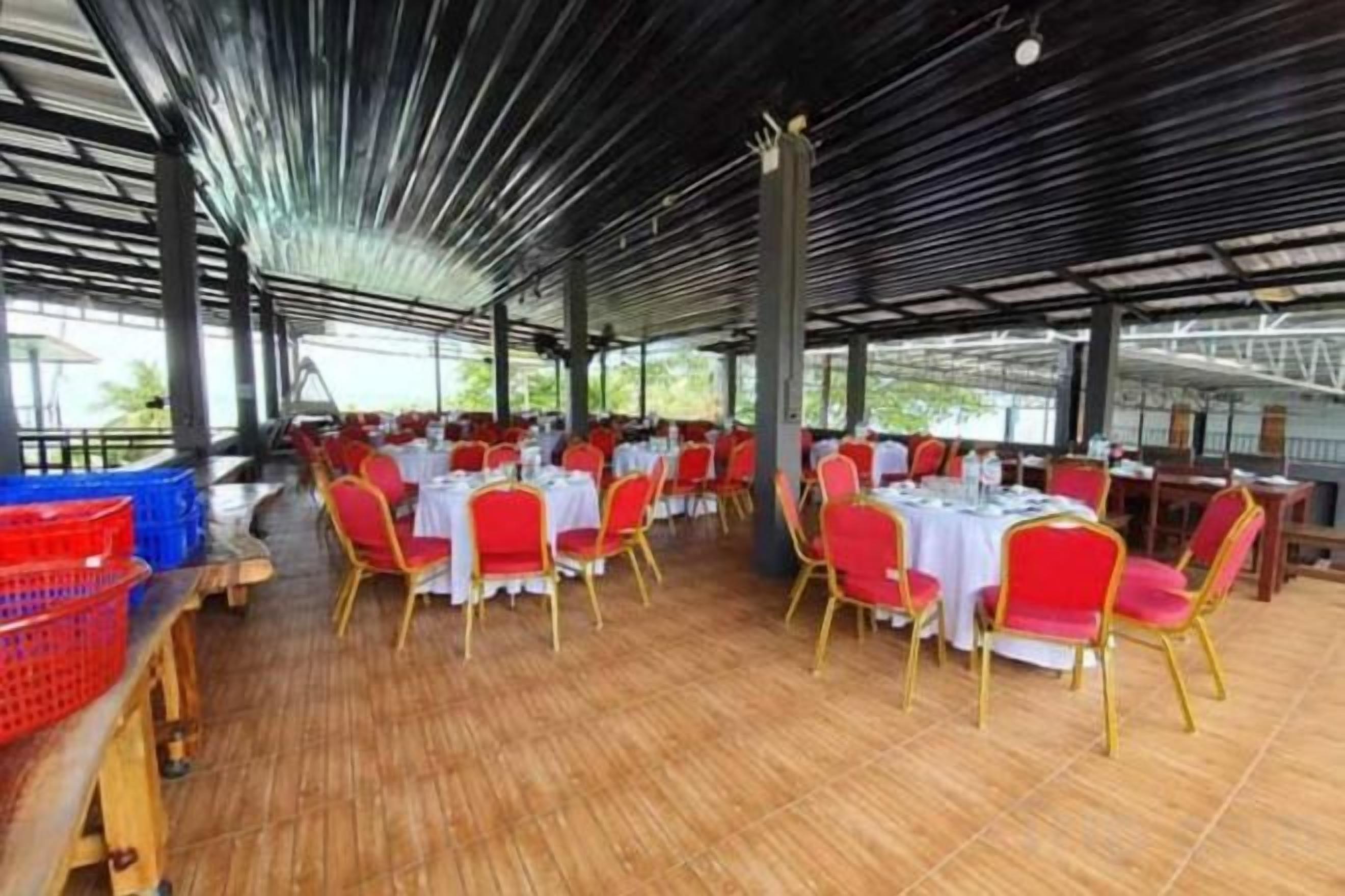 Un espacio de comedor al aire libre con techo, con mesas y sillas dispuestas para los huéspedes.