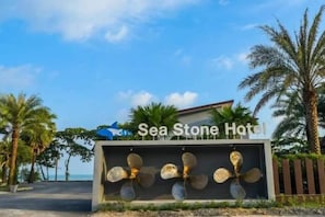 A sign for Sea Stone Hotel with a decorative fan display and palm trees in the background. - Sea Stone Hotel Sichon (Sichon)