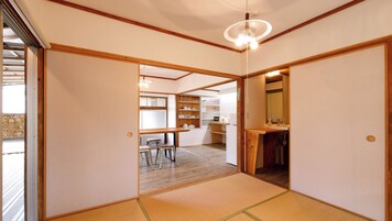 Una habitación japonesa tradicional con suelo de tatami, techo de madera y puertas correderas.