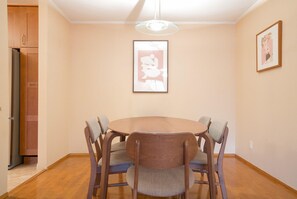 Enjoy meals in this cozy dining area with a round table and six chairs, surrounded by a warm atmosphere.