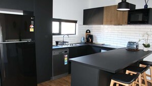 A modern kitchen with a black refrigerator, a coffee maker, and a toaster. - CBD Elizabeth St Modern Townhouse - Secure Parking (Launceston)