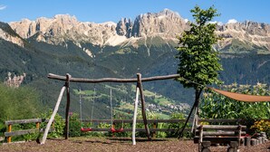 A wooden swing set with a view of mountains in the background.