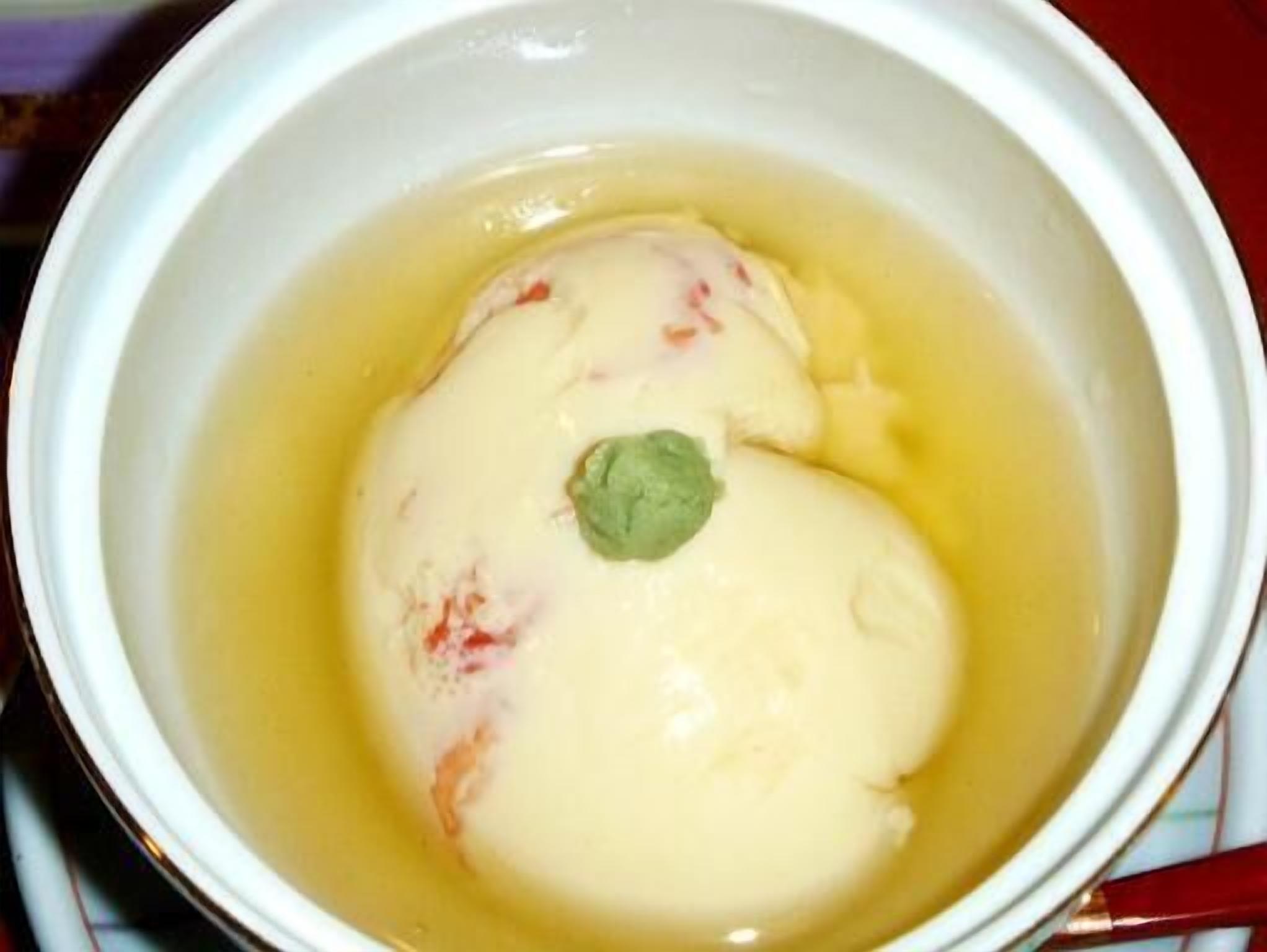 Eine Schüssel Suppe mit einem grünen Blatt als Dekoration.