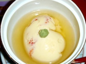 A bowl of soup with a green leaf garnish. - Minshuku Enogubako (Kazuno)