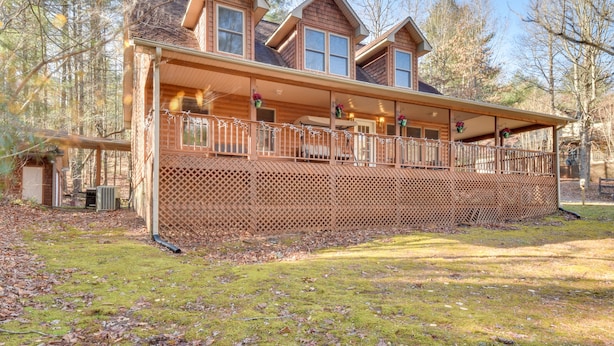 A two-story log cabin with a covered porch and a fenced deck. - Hiawassee Vacation Rental w/ Grill ~ 9 Mi to Lake! (Hiawassee)