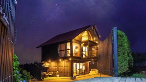 A two-story modern house with a balcony, large windows, and a well-lit entrance. - The Blackberry Cottage (Nuwara Eliya)