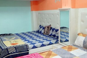 A bedroom with a bed, a mirror, and a wardrobe. - MAA VAISHNO GUEST HOUSE (Varanasi)