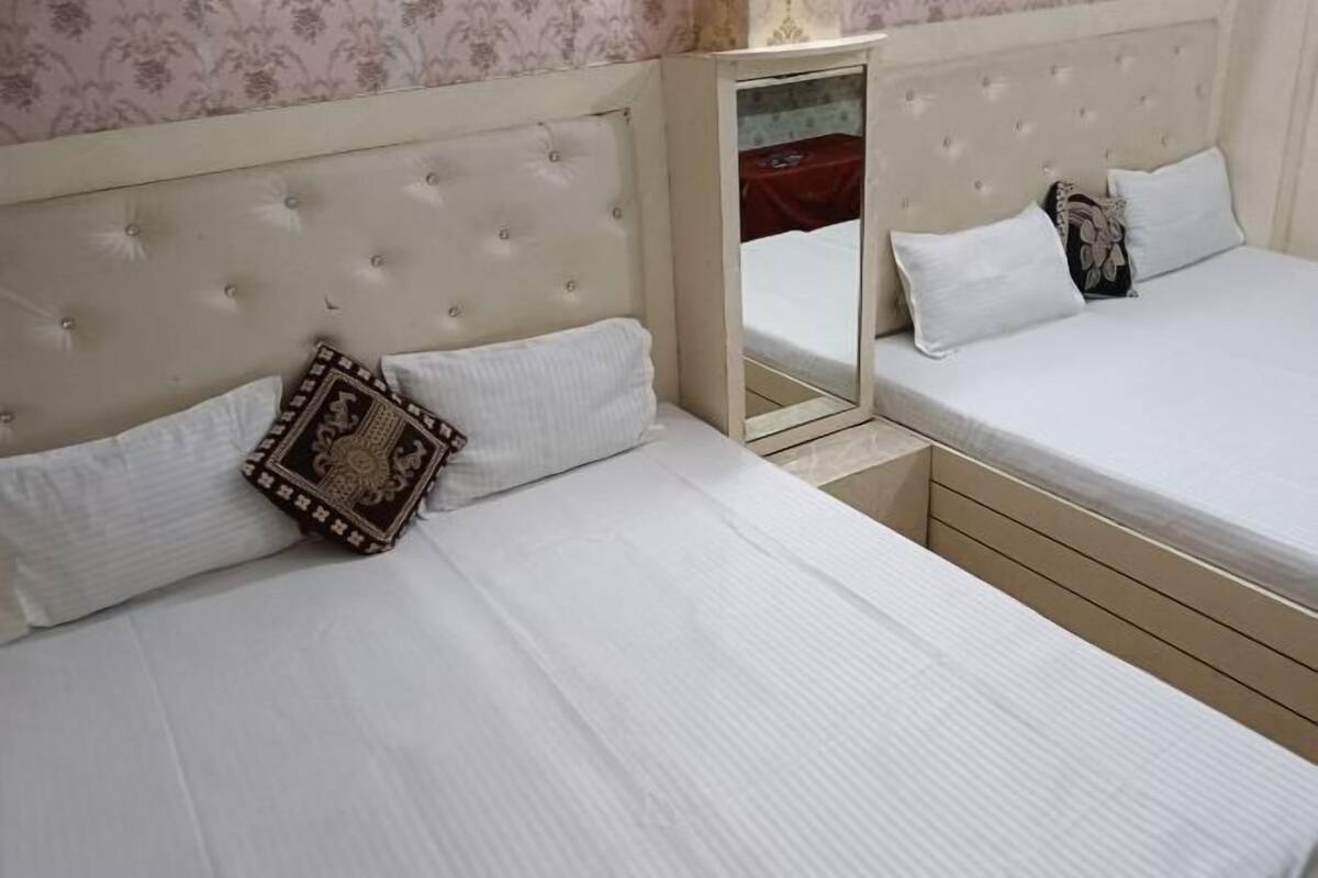 A double bed with a headboard, a bedside table, and a mirror.