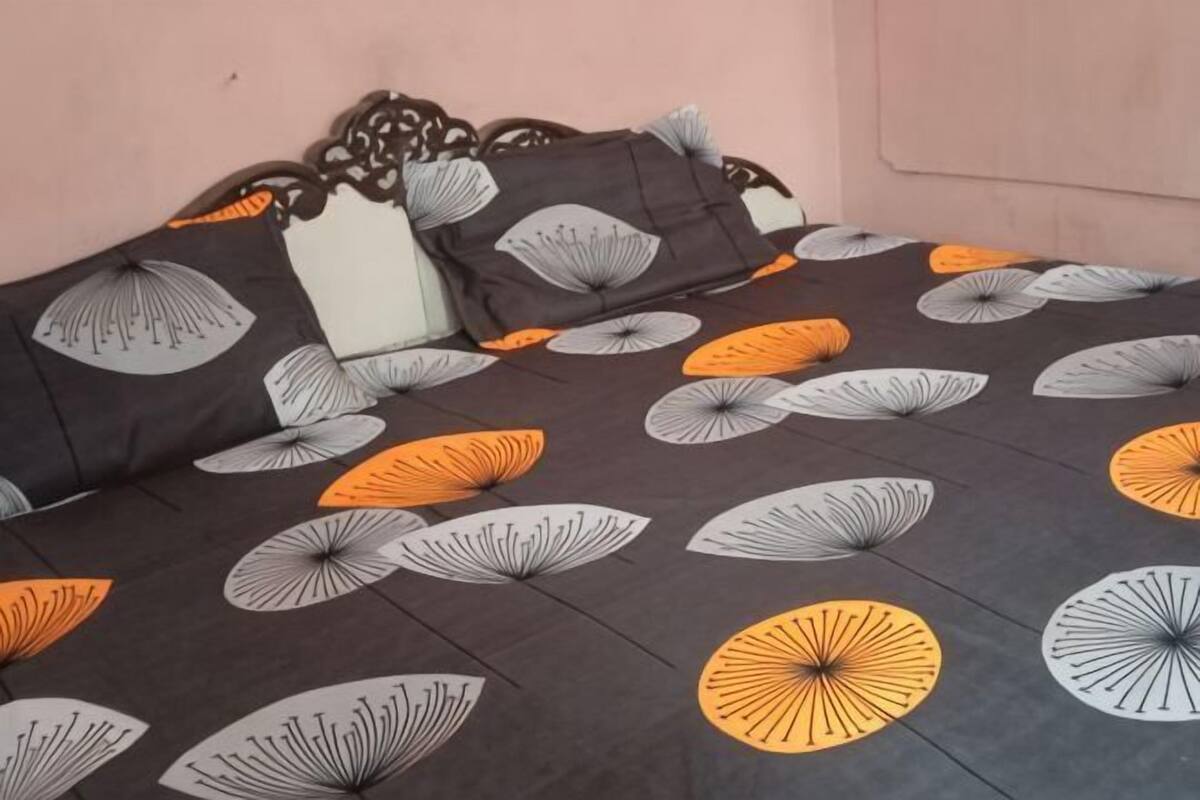 A bed with a patterned bedspread and pillows.