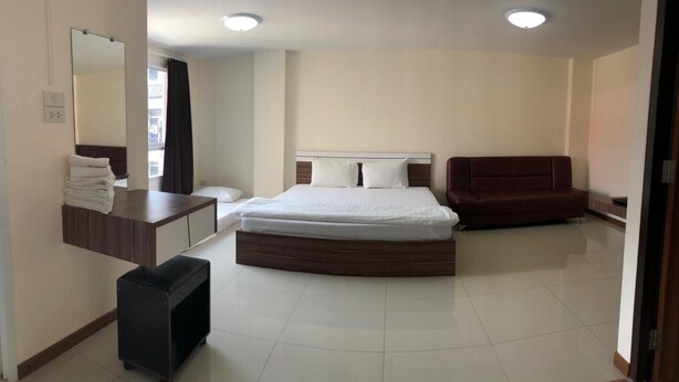 A bedroom with a bed, a desk, a chair, and a mirror. - My Room Nakhonpathom (Nakhon Pathom)