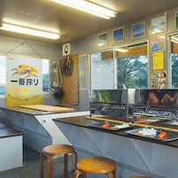 Una cocina con mostrador, taburetes y un póster.