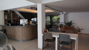 Um café moderno com balcão de madeira, área de estar e vista para o exterior.