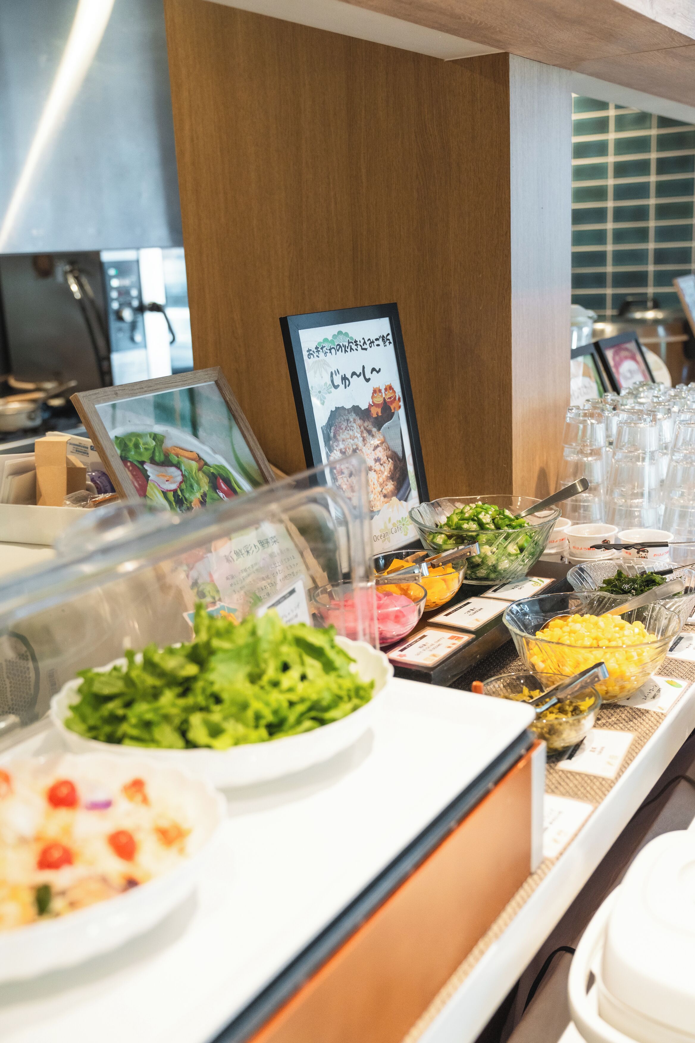 A buffet with various food items and a sign with Japanese text.
