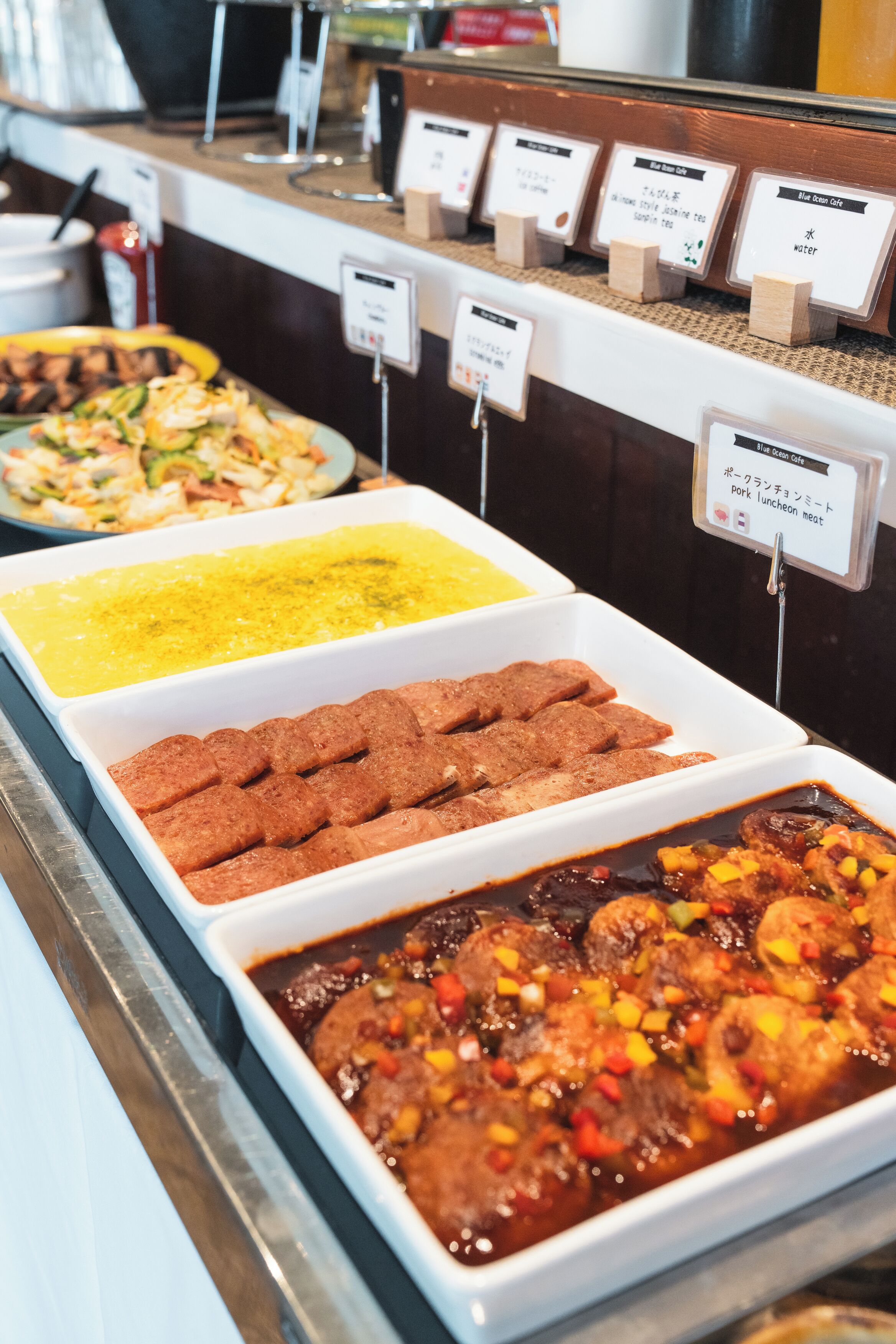 A buffet with various dishes and labels indicating different types of food.