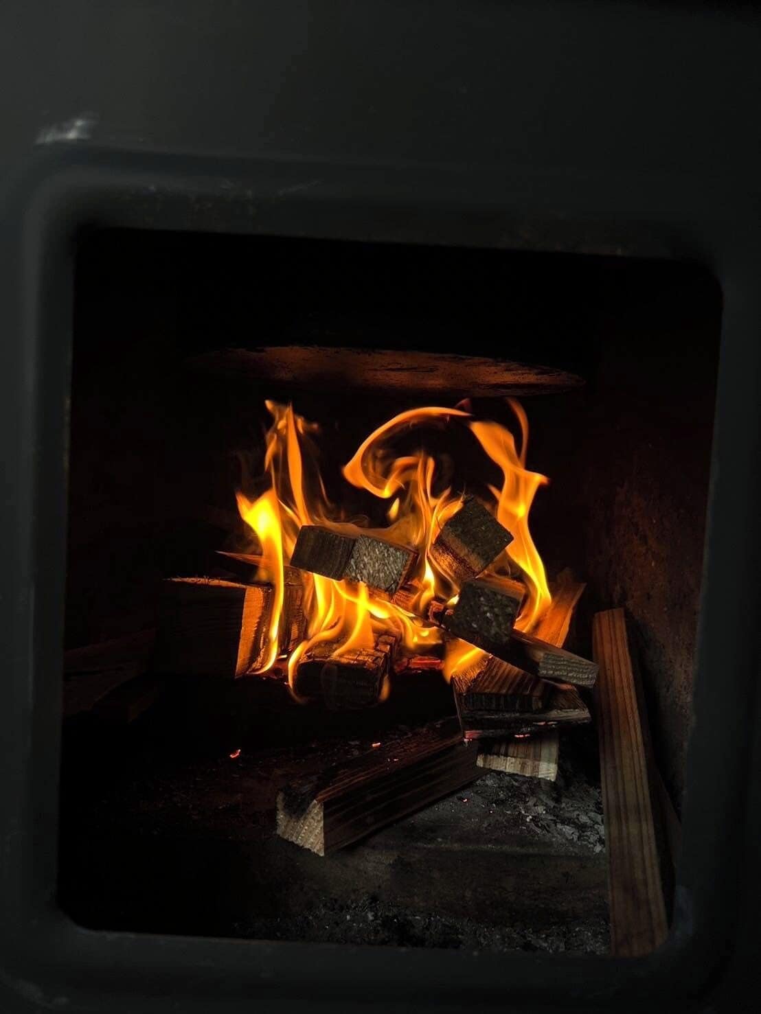 A fireplace with burning logs inside a fireplace.