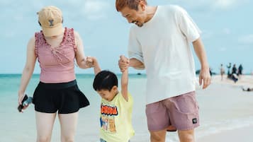 Una famiglia che cammina su una spiaggia sotto cieli sereni.
