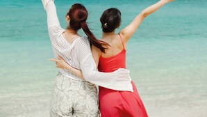 Two people standing at a beach with a clear sky and ocean in the background. - Nest Hotel Ishigaki Maesato Beach (Ishigaki)