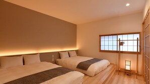 Ein Hotelzimmer mit zwei Betten, einem Fenster mit Ausblick und Holzboden.