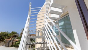 A white exterior of a building with a metal staircase leading to a window. - Apartment 'Appartamento Luna' with Sea View, Wi-Fi and Air Conditioning (Santa Croce Camerina)