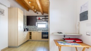 A modern kitchen with wooden cabinets, a tiled backsplash, and a built-in oven. - Apartment 'Appartamento Luna' with Sea View, Wi-Fi and Air Conditioning (Santa Croce Camerina)