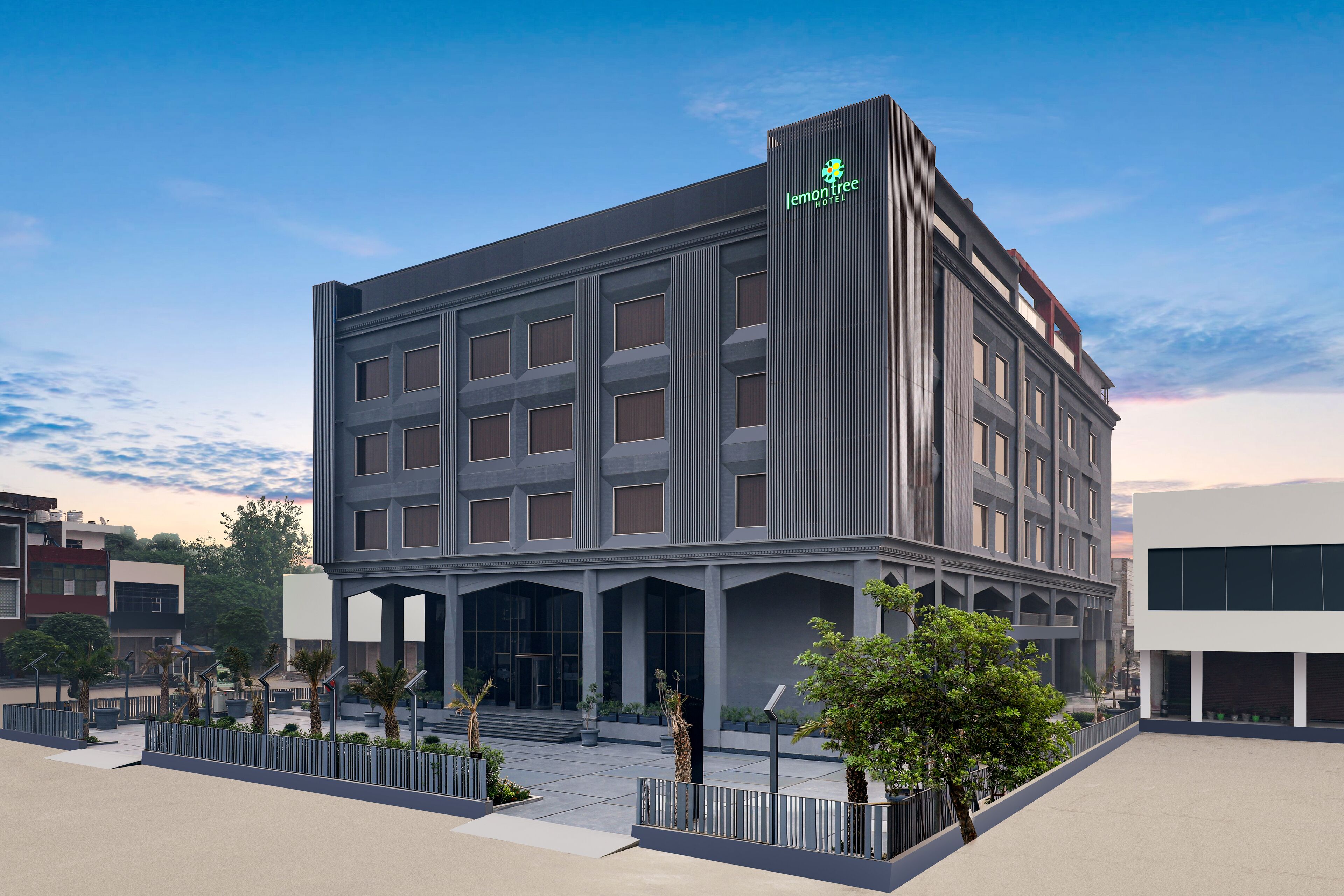 A modern hotel with a prominent vertical sign, large windows, and a spacious entrance area.