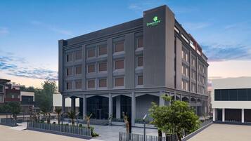 A modern hotel with a prominent vertical sign, large windows, and a spacious entrance area.
