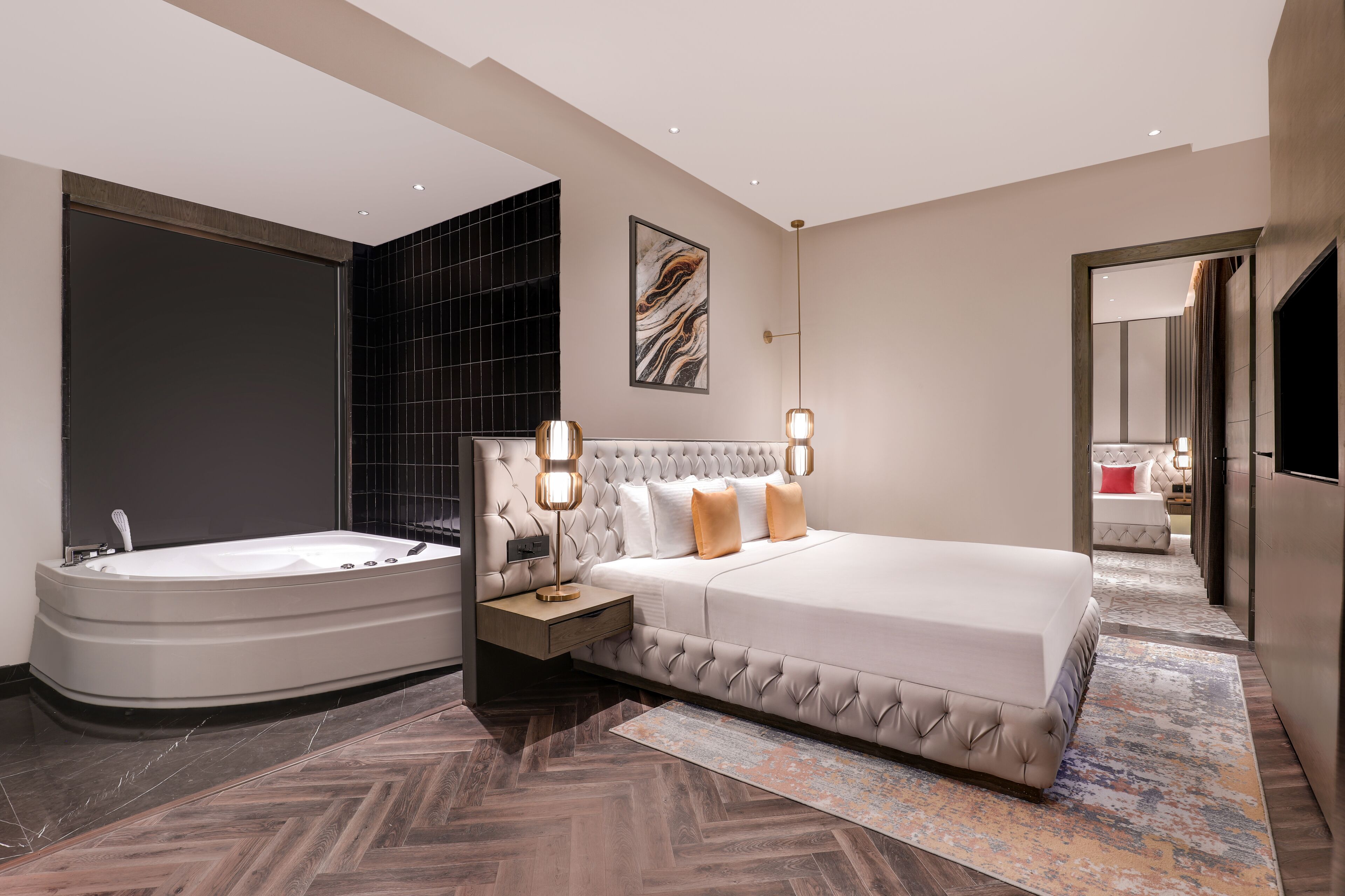 A modern bedroom with a large bed, a separate bathroom, and a herringbone-patterned floor.