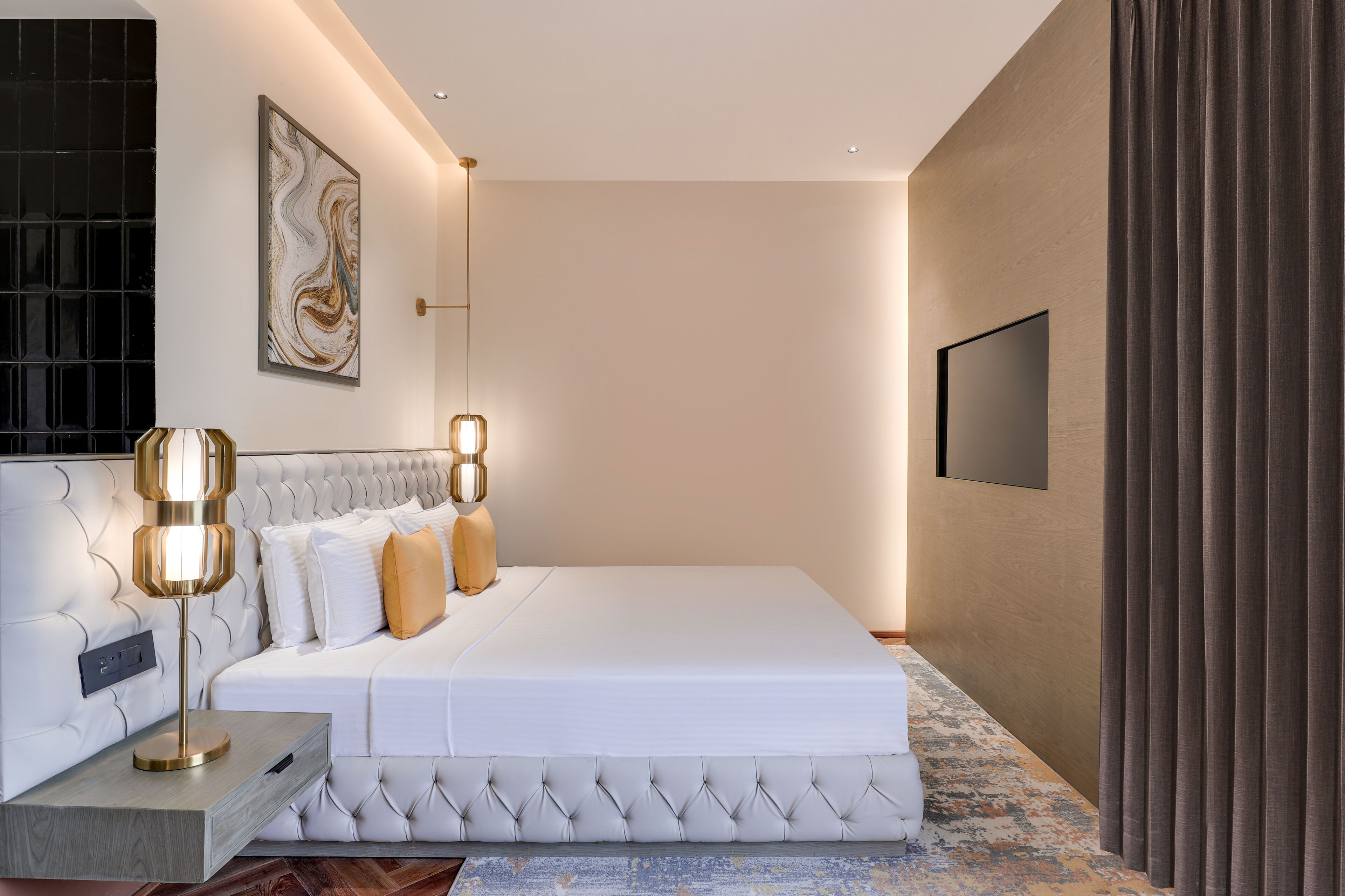 Camera da letto moderna con un letto grande, un comodino, una TV a parete e un apparecchio di illuminazione decorativo.