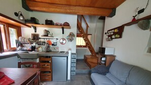 A compact living space with a kitchen, dining area, and a staircase leading to an upper level. - Holiday Home 'La Casina Rossa Della Fornace' with Mountain View, Private Garden & Wi-Fi (Cutigliano)