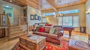 A spacious living room with a wooden ceiling, a pool table, a leather sofa, and a staircase. - Cimmaron Sky by Velo (Angel Fire)