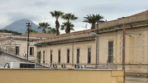 Un bâtiment à la façade beige, une enseigne indiquant « Fattoria Didatica », et une montagne en arrière-plan.