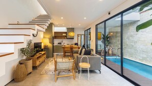 Un intérieur moderne comprenant un escalier, une cuisine, un coin repas et une piscine.