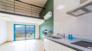 Eine moderne Küche mit einem großen Fenster, einem Einbauherd und Blick ins Freie.