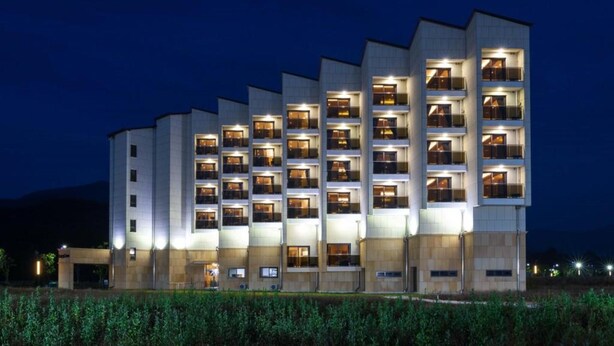Ein mehrstöckiges Hotel mit modernem Design, das Balkone auf jeder Etage hat.
