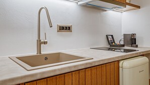 Moderni keittiö, jossa on ruostumattomasta teräksestä valmistettu hana, sisäänrakennettu uuni ja astianpesukone.