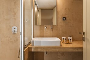 A modern bathroom with a rectangular sink, a mirror, and a shower enclosure. - Apartment In A Hotel 'Makava Family Suite' with Private Terrace, Wi-Fi and Air Conditioning (Naxos)