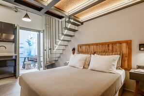 A modern bedroom with a large bed, a wooden headboard, a built-in wardrobe, and a staircase leading to an outdoor area. - Apartment In A Hotel 'Makava Family Suite' with Private Terrace, Wi-Fi and Air Conditioning (Naxos)