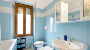 Un baño con bañera, inodoro, bidé y lavamanos.