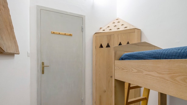 Una habitación con literas, una puerta y un armario.