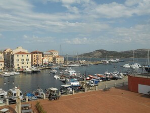 Un puerto deportivo con barcos, edificios y cielo despejado.