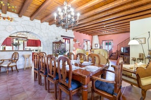 A dining area with a stone wall, wooden ceiling, and a chandelier. - Villa 'Ira' with Sea View, Wi-Fi and Air Conditioning (?????T?S)