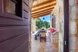An outdoor patio with stone flooring, wooden beams, and a stone wall. - Villa 'Ira' with Sea View, Wi-Fi and Air Conditioning (?????T?S)