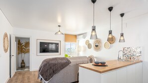 Une cuisine moderne dotée d’un plan de travail en bois, de luminaires suspendus et d’un évier encastré.